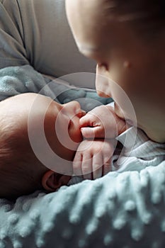 Woman and man holding on hands a newborn. Mother kissing her son. Portrait of young family. Happy family life. Man was born