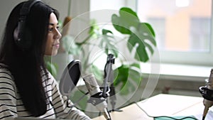 Woman and man influencer recording podcasts audio interview on microphone in home studio Spbd