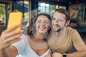 Woman and man joyfully looking at smartphone screen