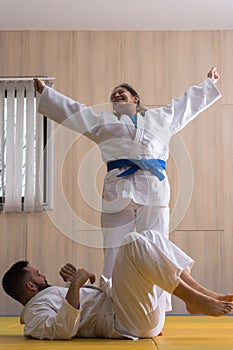 Woman and man judo fighters in sport hall