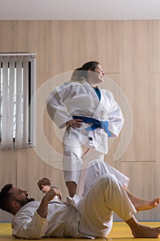 Woman and man judo fighters in sport hall