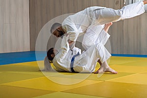 Woman and man judo fighters in sport hall