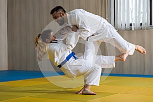 Woman and man judo fighters in sport hall