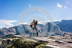 Woman and man kissing lovingly while mountain hiking