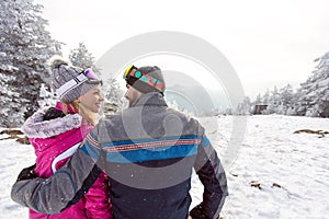Woman and man in love on winter holiday together, back view