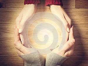 Woman and man making circle with hands. Warm light inside