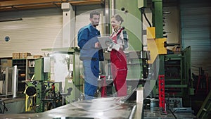 Woman and man manufacturing worker in discussion