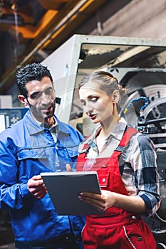 Woman and man manufacturing worker in discussion