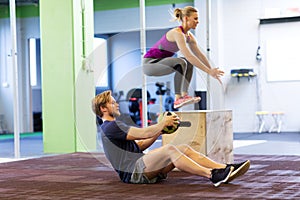 Woman and man with medicine ball exercising in gym