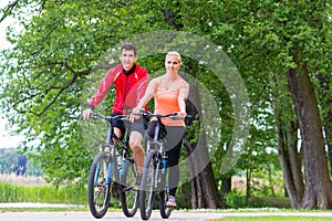 Woman and man on mountain bike in the woods