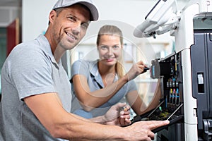 woman and man opening photocopy machine in office