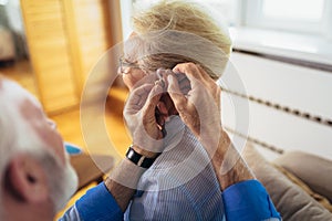 Woman and man or pensioners with a hearing problem
