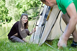 Woman and man pitching a tent