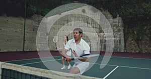 Woman and man playing tennis on a court