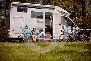 Woman with a man resting near motorhomes in nature. Family vacation travel, holiday trip in motorhome RV, Caravan car Vacation.