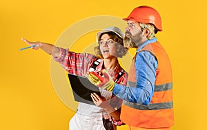 Woman and man safety hard hat. Redevelopment of home. Couple look documents. Couple planning changes renovation