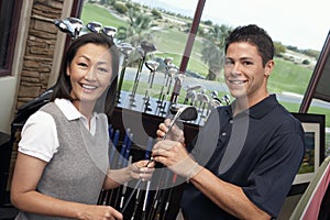 Woman With Man Selecting Golf Club photo