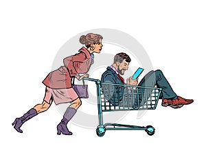 Woman with a man in a shopping cart in a supermarket