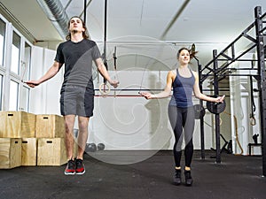 Woman and man skipping rope at the gym