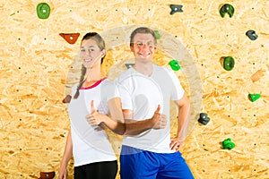 Woman and man standing at climbing wall