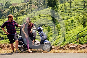 Woman and man traveler resting on motobike in tea plantations in india kerala munnar