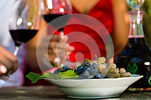 Woman and man in vineyard drinking wine