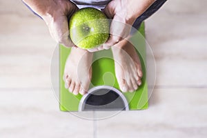 Woman or man on a weight scale showing an apple and select his lifestyle - good nutition concept