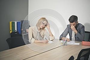 Woman and man work together at desk. Businesswoman and businessman have business meeting in office. Concentrated on work