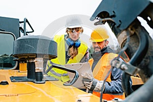 Woman and man worker in quarry on excavation machine