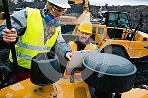 Woman and man worker in quarry on excavation machine