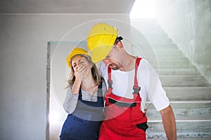 Woman and man workers suffocating at the construction site.