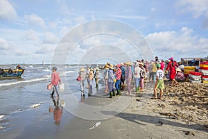 Woman and man working on the beach near Long Hai fish market