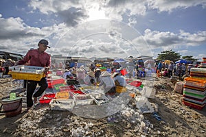 Woman and man working on the beach near Long Hai fish market