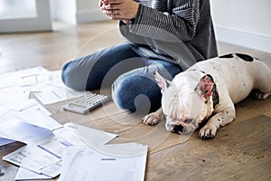 Woman managing the debt and using phone near pet dog
