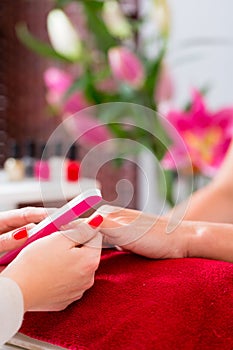 Woman at manicure in nail parlor with file