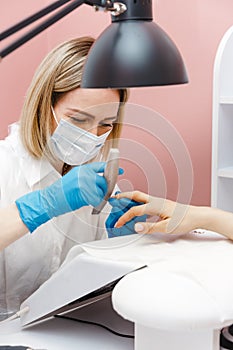 Woman on manicure treatment in beauty salon. Manicure, beauty procedures and personal care. Portrait