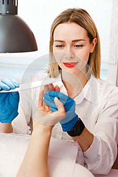 Woman on manicure treatment in beauty salon. Manicure, beauty procedures and personal care. Portrait