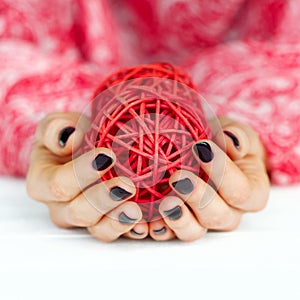 Woman manicured hands holding deco ball