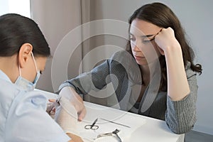 Woman manicurist master is removing cuticle and pterygium using pusher. photo