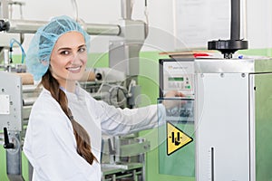 Woman manufacturing engineer adjusting the settings of an industrial machine