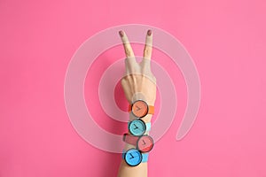 Woman with many bright wrist watches on color background, closeup. Fashion photo