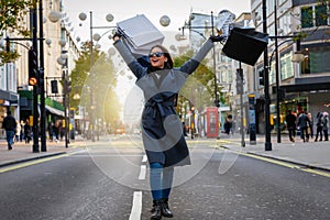 Woman with many shopping bags in her hand walking down Oxford Street photo