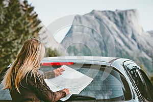 Woman with map planning route traveling by rental car