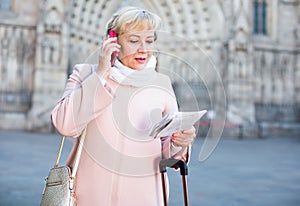 woman with map talking mobile phone