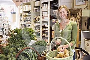 Woman in market looking at potatoes smiling