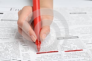 Woman marking advertisement in newspaper. Job search concept