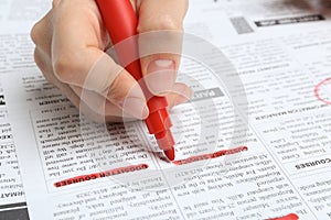Woman marking advertisement in newspaper. Job search concept