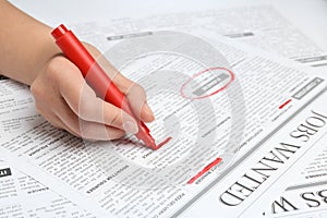 Woman marking advertisement in newspaper. Job search concept