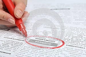 Woman marking advertisement in newspaper. Job search concept