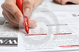 Woman marking advertisement in newspaper. Job search concept